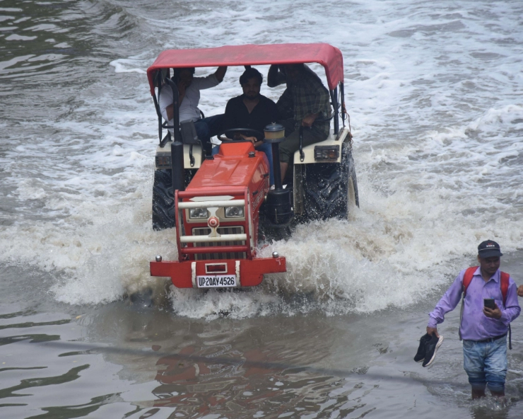 A tractor wades through a waterlogged road at ITO as the Yamuna river inundates nearby areas, in New Delhi