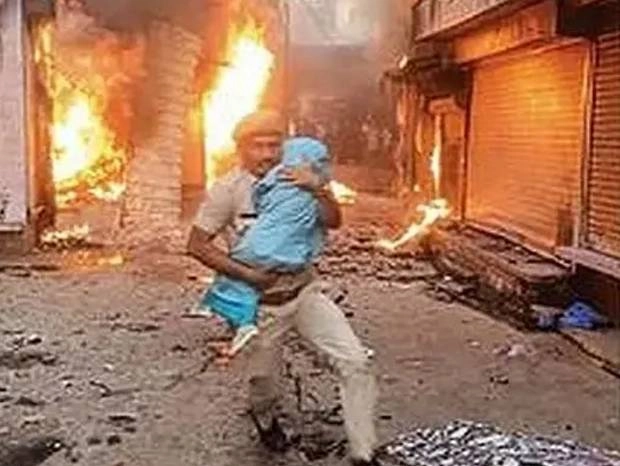 पुलिस कांस्टेबल को सलाम, मासूम को बचाने के लिए आग की लपटों में लगाई छलांग - karauli communal clash photo viral of rajasthan police constable netresh sharma