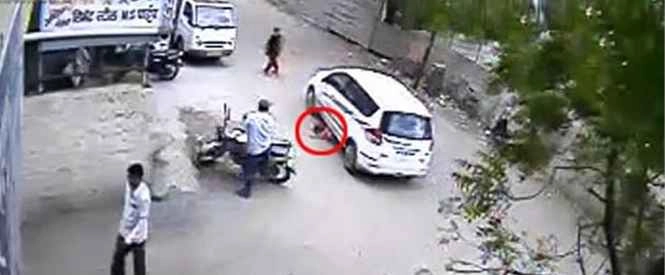 कार के नीचे आई बच्ची, जीवित बची (वीडियो) - Baby, car accident