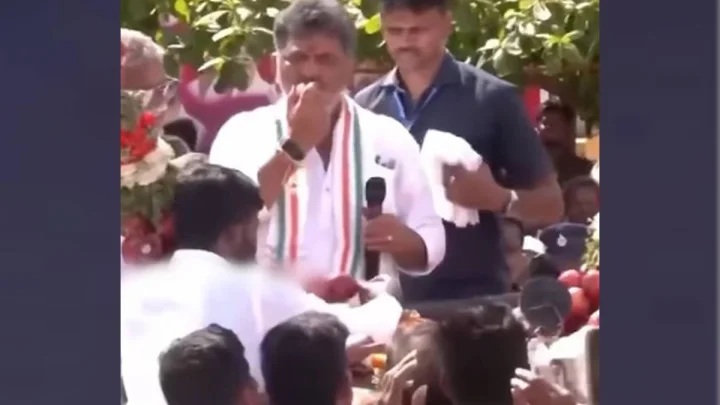 యాపిల్ పండును కొరికి ఆ ఎంగిలి పండును జనంపైకి విసిరిన కర్నాటక సీఎం డికె శివకుమార్, వీడియో